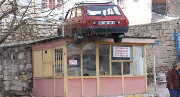 Niğde'de otomobil muhtarlığın çatısına uçtu